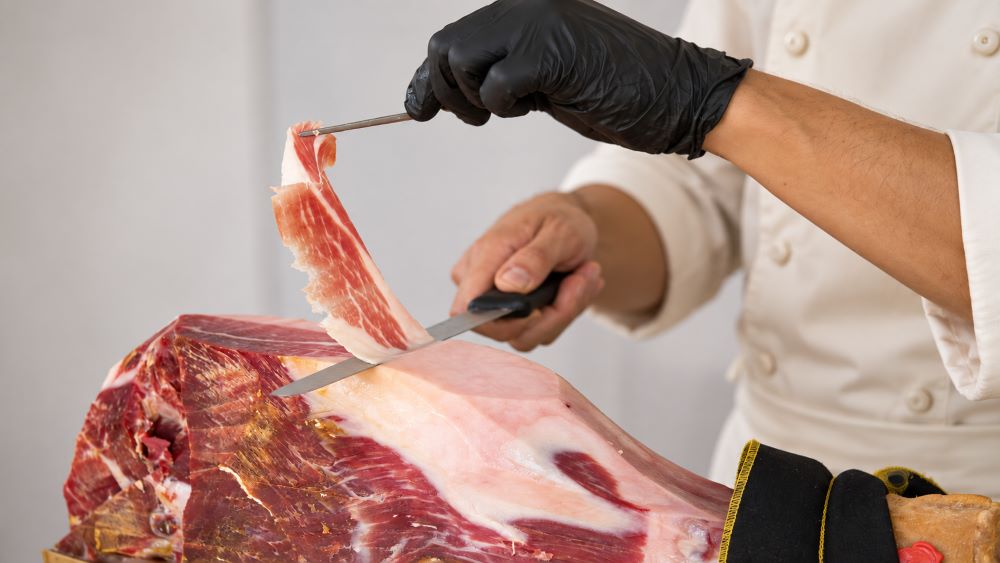 Taglio a coltello di un prosciutto di Parma